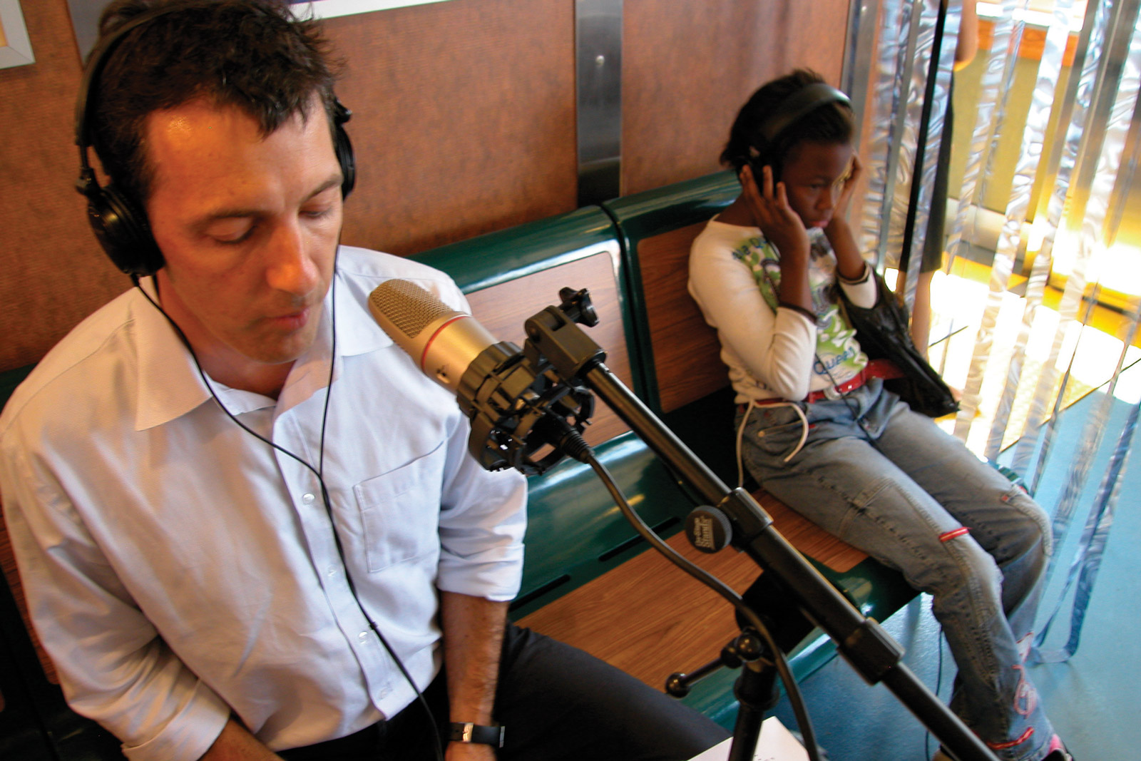 The FM Ferry Experiment studio on the John J. Marchi Staten Island Ferry. Image features (left to right) on-air guest Alex Matthiessen of Riverkeeper and ferry rider listening in.
